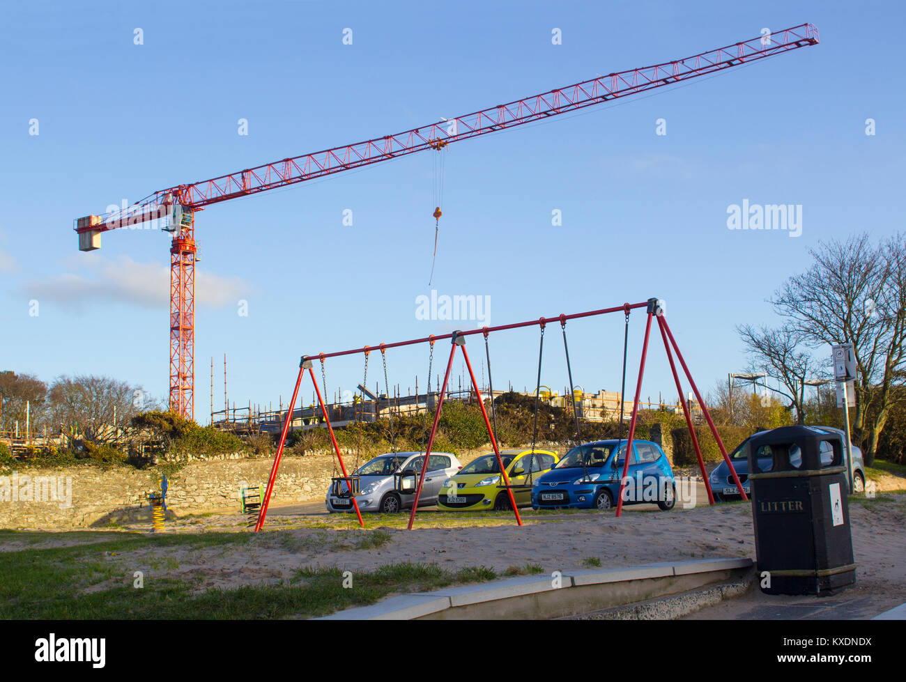 A tall static tower crane towering above the Banks childrens playground while in use on a building project in Bangor County Down Northern Ireland Stock Photo