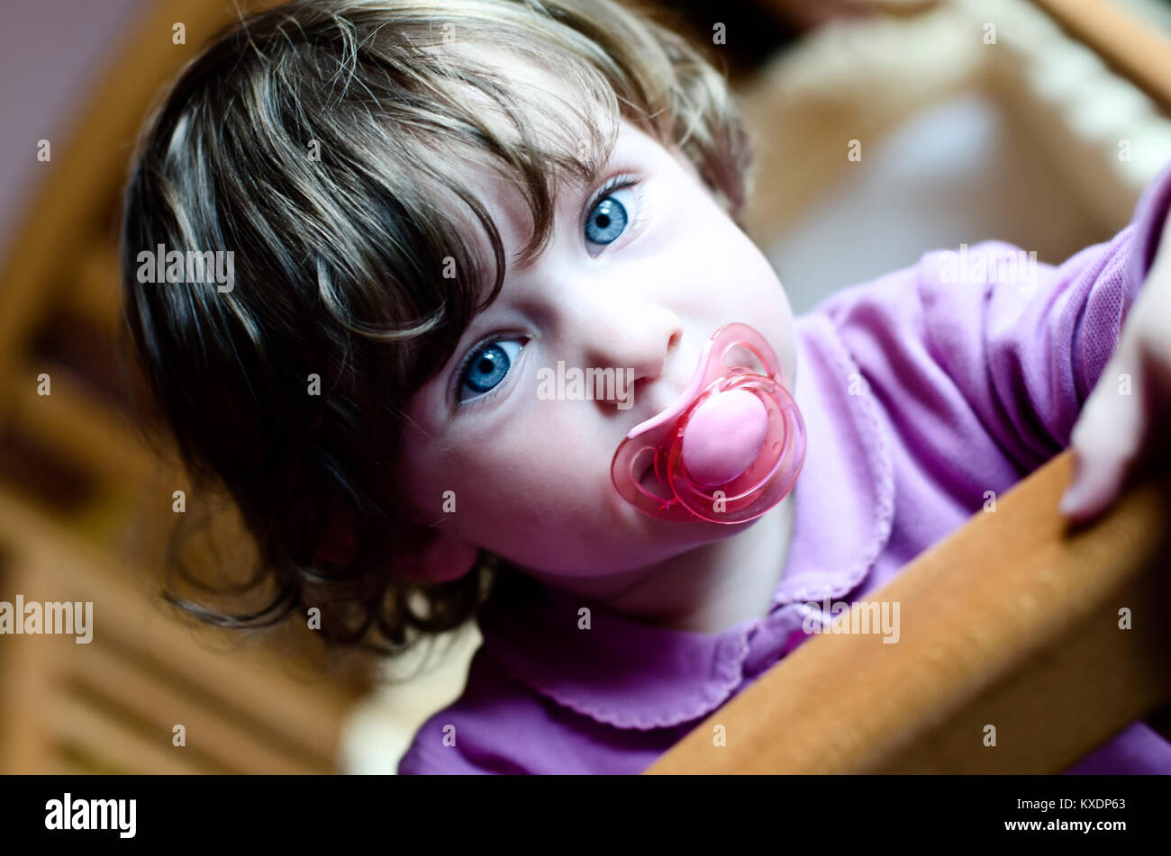 cute baby girl with a soother in her mouth Stock Photo Alamy