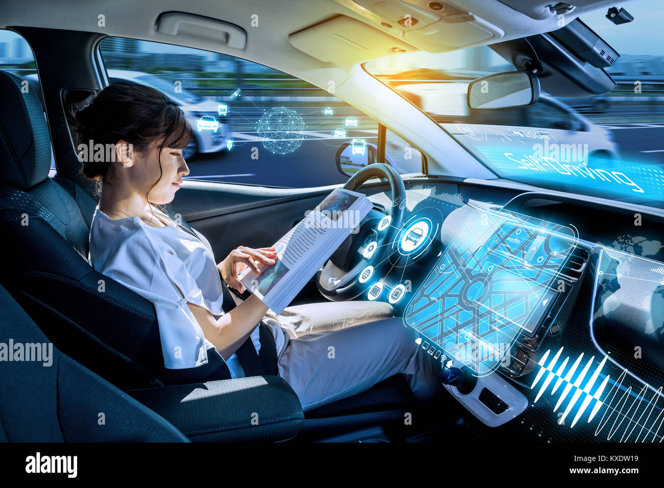 young woman reading a book in a autonomous car. driverless car. self driving vehicle. heads up display. automotive technology. Stock Photo