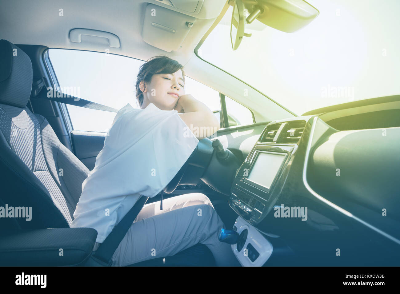 young female driver sleeping in vehicle. Stock Photo