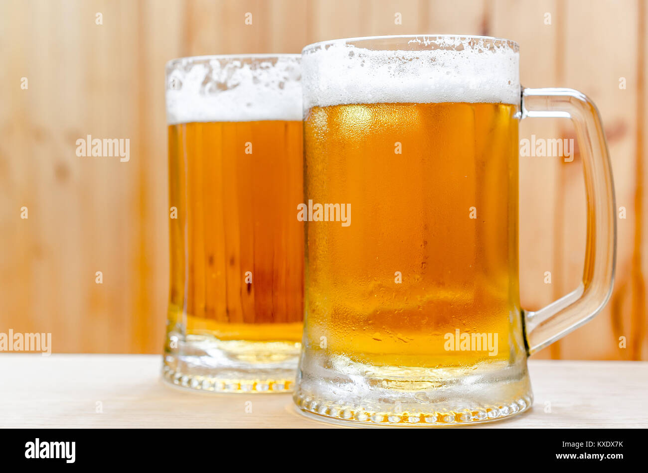 Two beer mugs on the wooden background Stock Photo