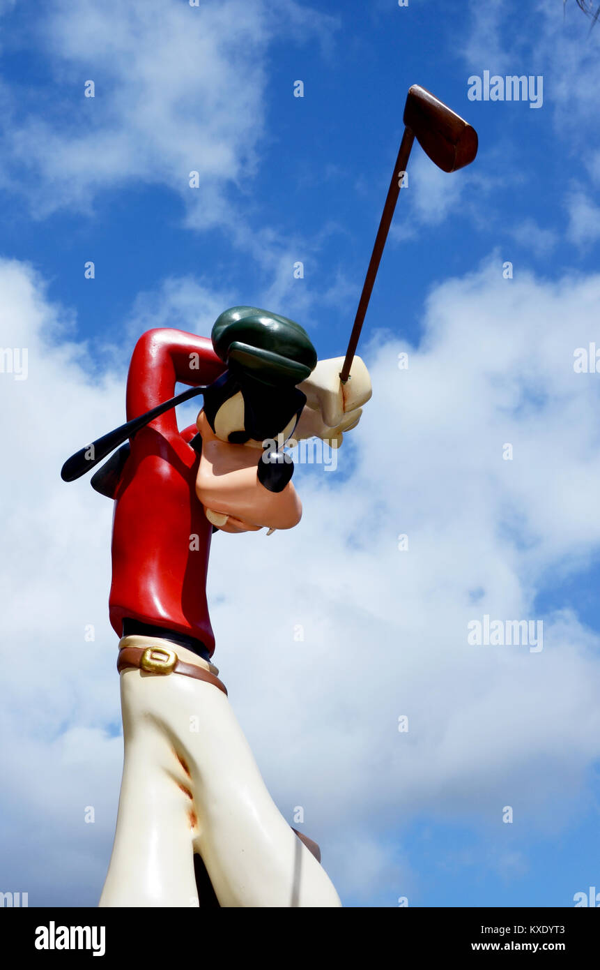 Monchique, Faro - Portugal, Circa, March 2013. Studio image of Goofy figure swinging a golf club with a blue sky background. Stock Photo