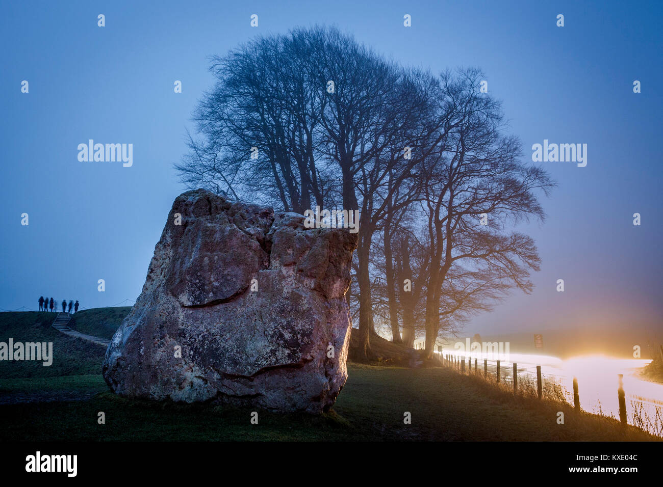 People gather in the mist and grey overcast weather at Avebury stone circle to watch the rising of the sun on the day of the winter solstice, the shortest day of the year. Stock Photo