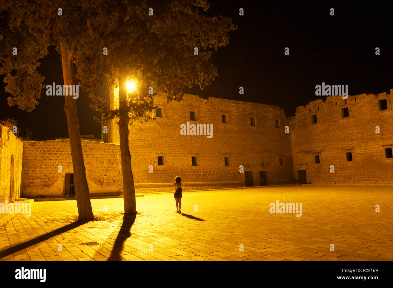 The old walled city of Famagusta by night with a woman taking a photo of the wall, Cyprus Stock Photo