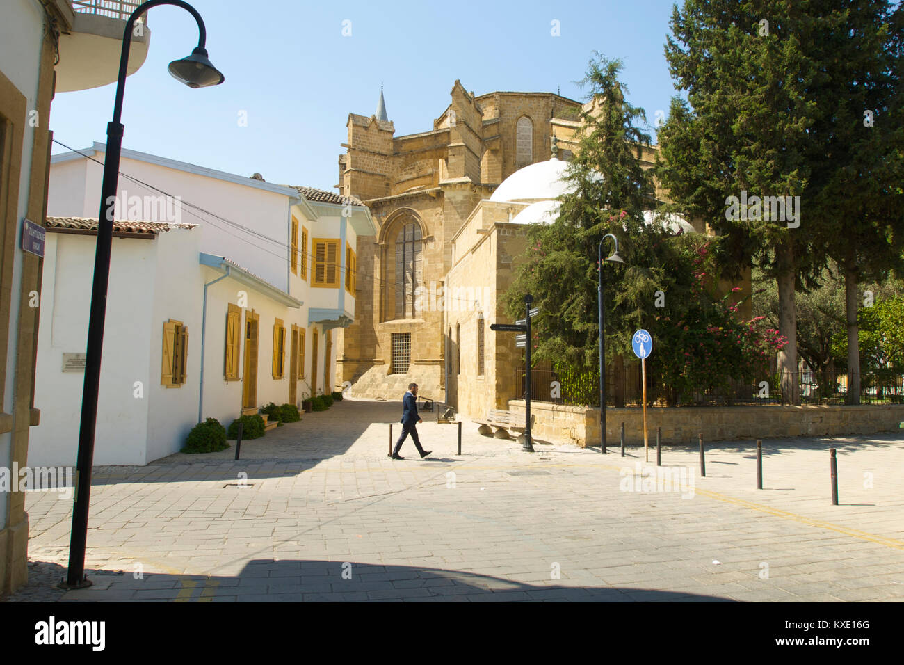A local man crossing the road in North Nicosia with a mosque in the background that used to be a church, Cyprus Stock Photo