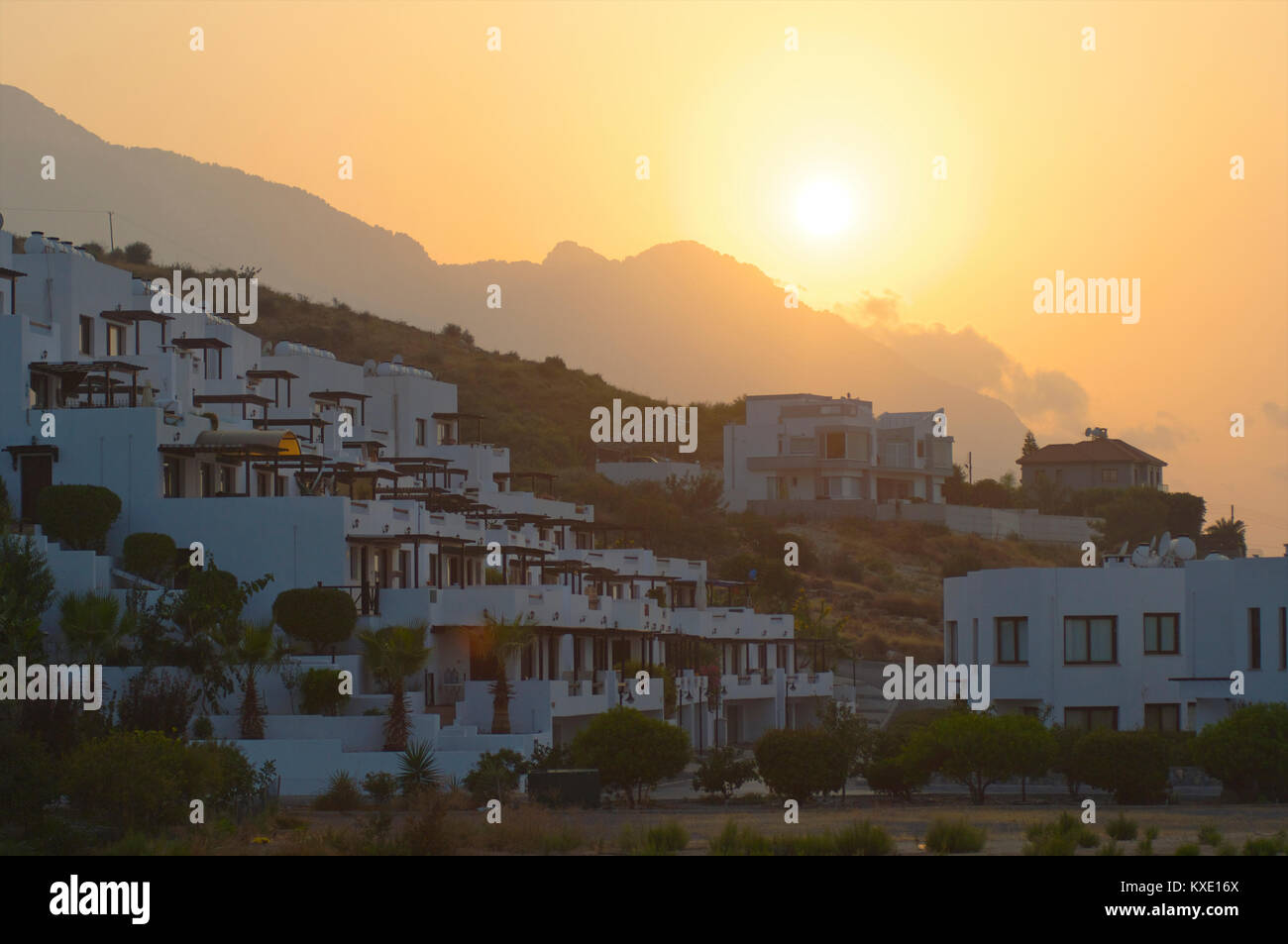 Sunset behind the mountains with houses build against the mountain in Kyrenia, Cyprus Stock Photo