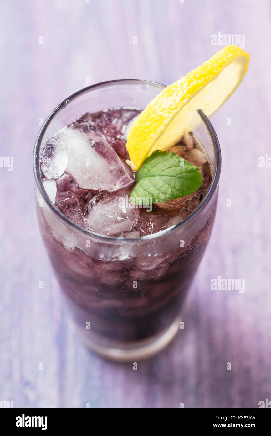 Long drink with elderberry and redcurrant vodka, elderberry syrup, sparkling water and lime juice Stock Photo