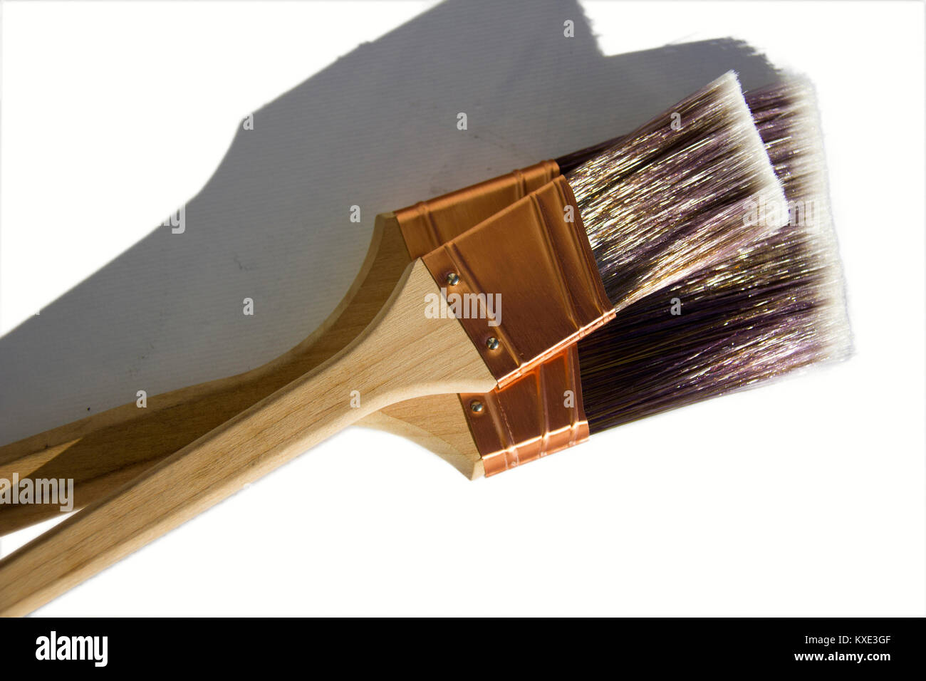 Large synthetic high quality paint brushes sitting on a paint tin with