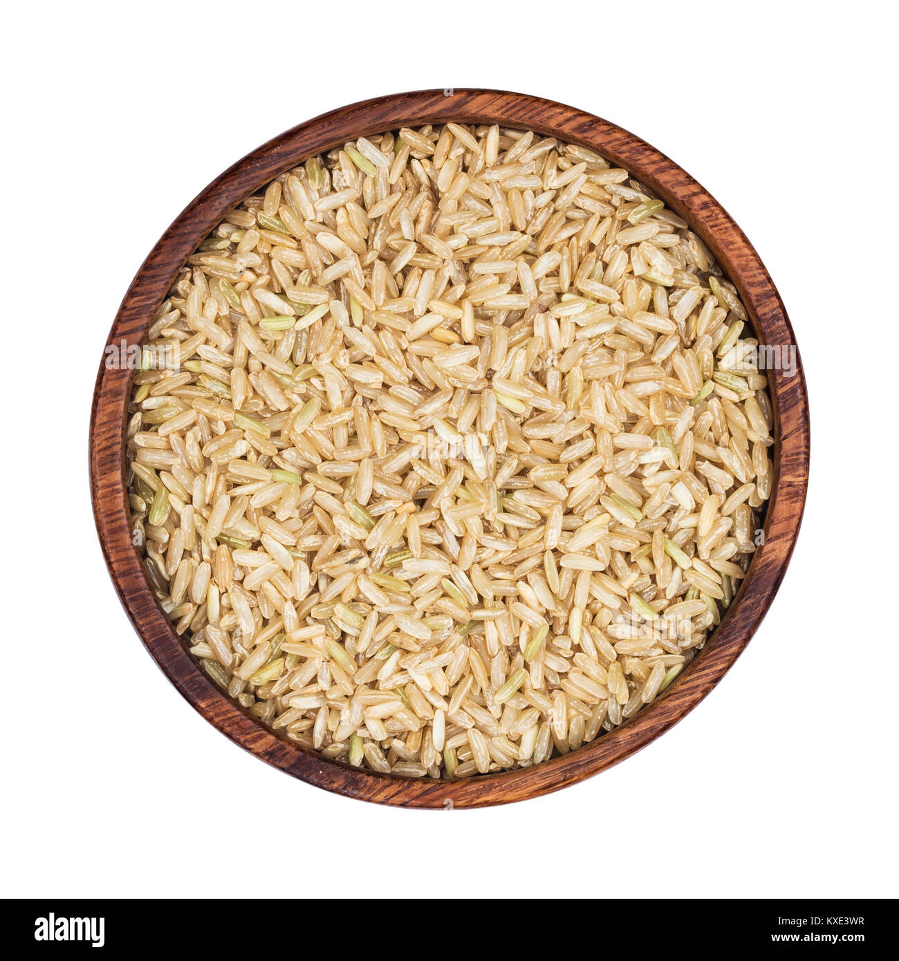 Brown rice groats in wooden bowl isolated on white background. Top view Stock Photo
