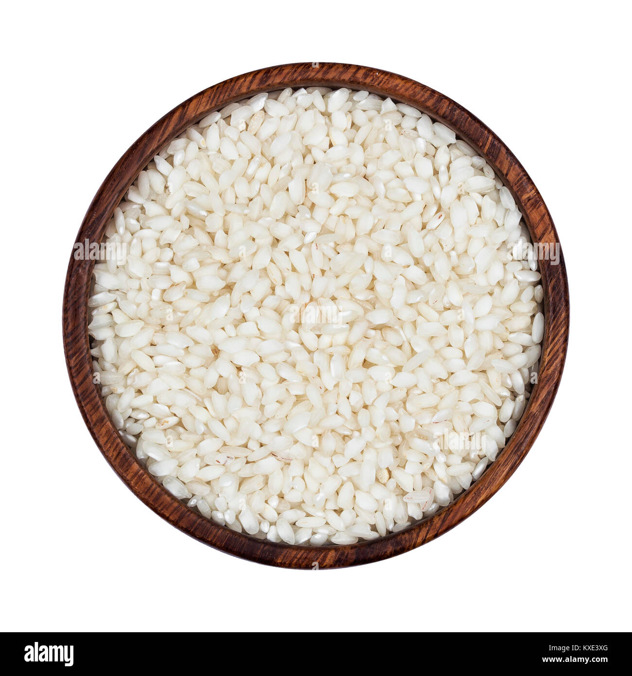 Risotto rice in wooden bowl isolated on white background. Top view Stock Photo