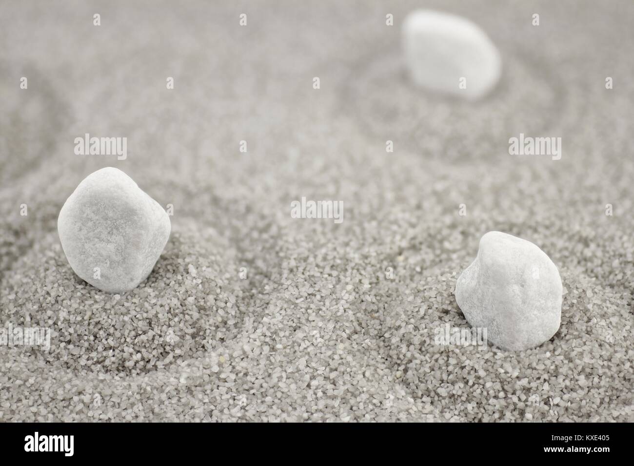 White pebbles in gray sand with circles Stock Photo