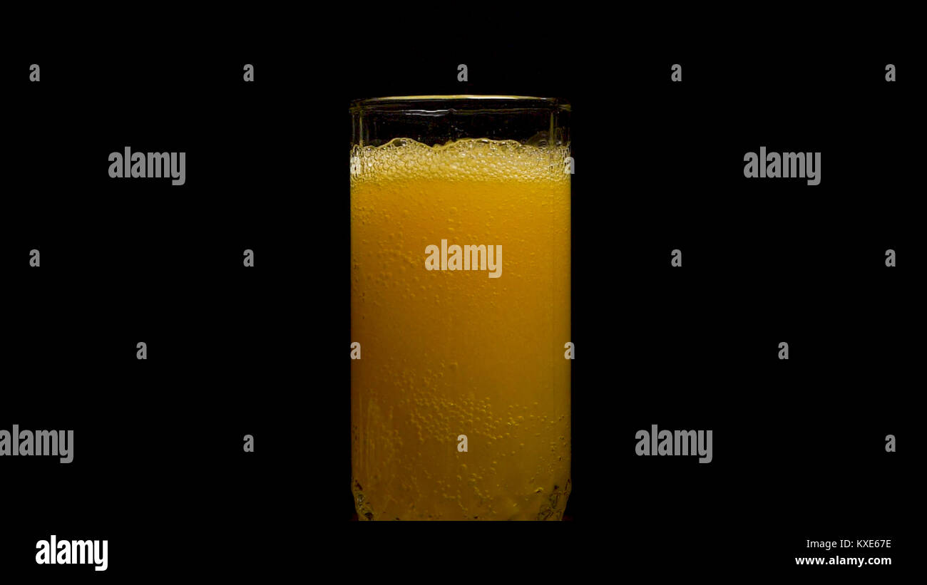 Orange soda large glass, overflowing glass of orange soda closeup with