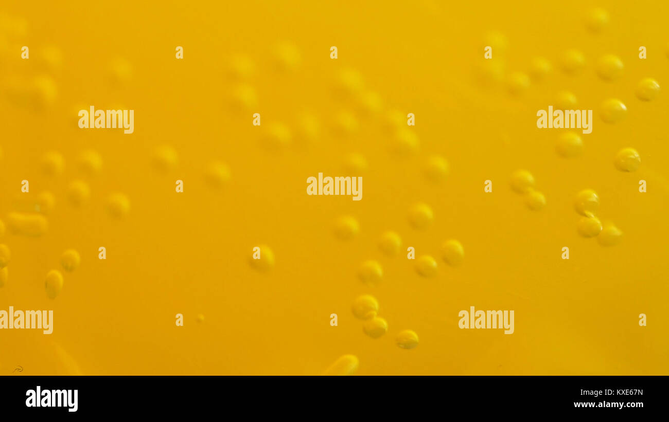 Orange soda with bubbles background. Fresh orange fruit in a glass of