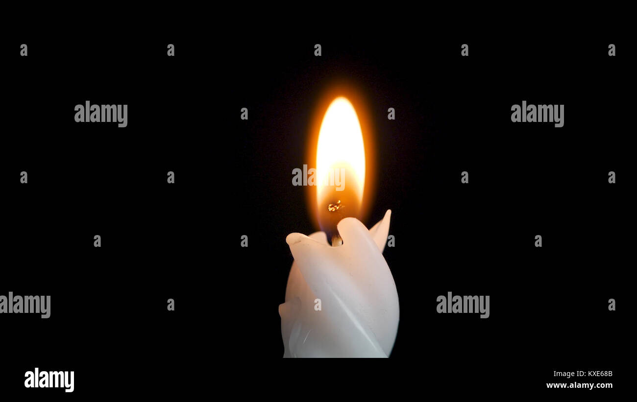 White long candle on black background. Single candle flame light. Long