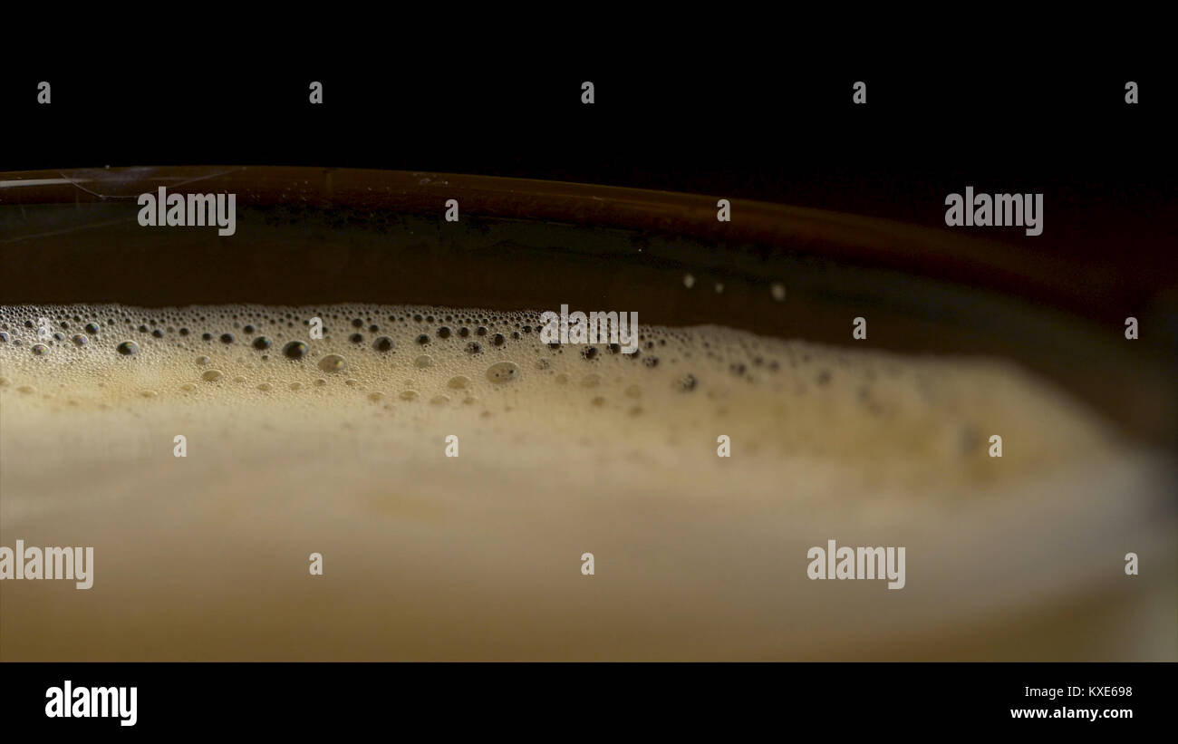 Close-up of coffee foam isolated over a black background, viewed from ...