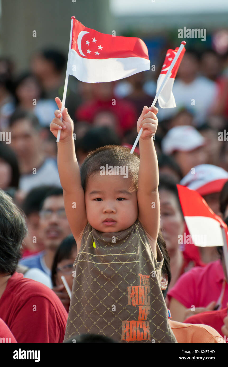 SINGAPORE AUGUST 9 Cute boy celebrating National Day by holding up
