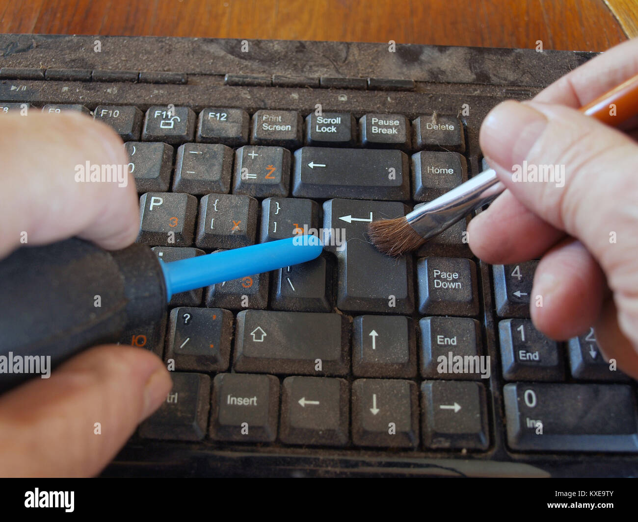 Cleaning dirty dusty computer keyboard by hand air blower and brush