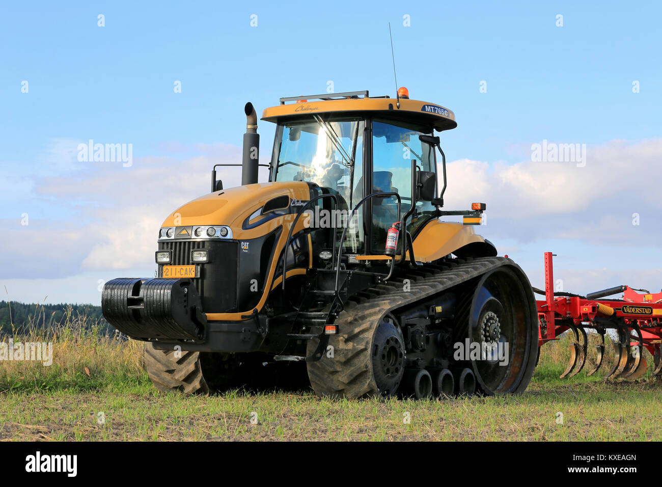 SALO, FINLAND -SEPTEMBER 6, 2014: Challenger MT765C crawler tractor and cultivator on field. MT765C has Caterpillar 8.8L 6-cyl diesel engine. Stock Photo