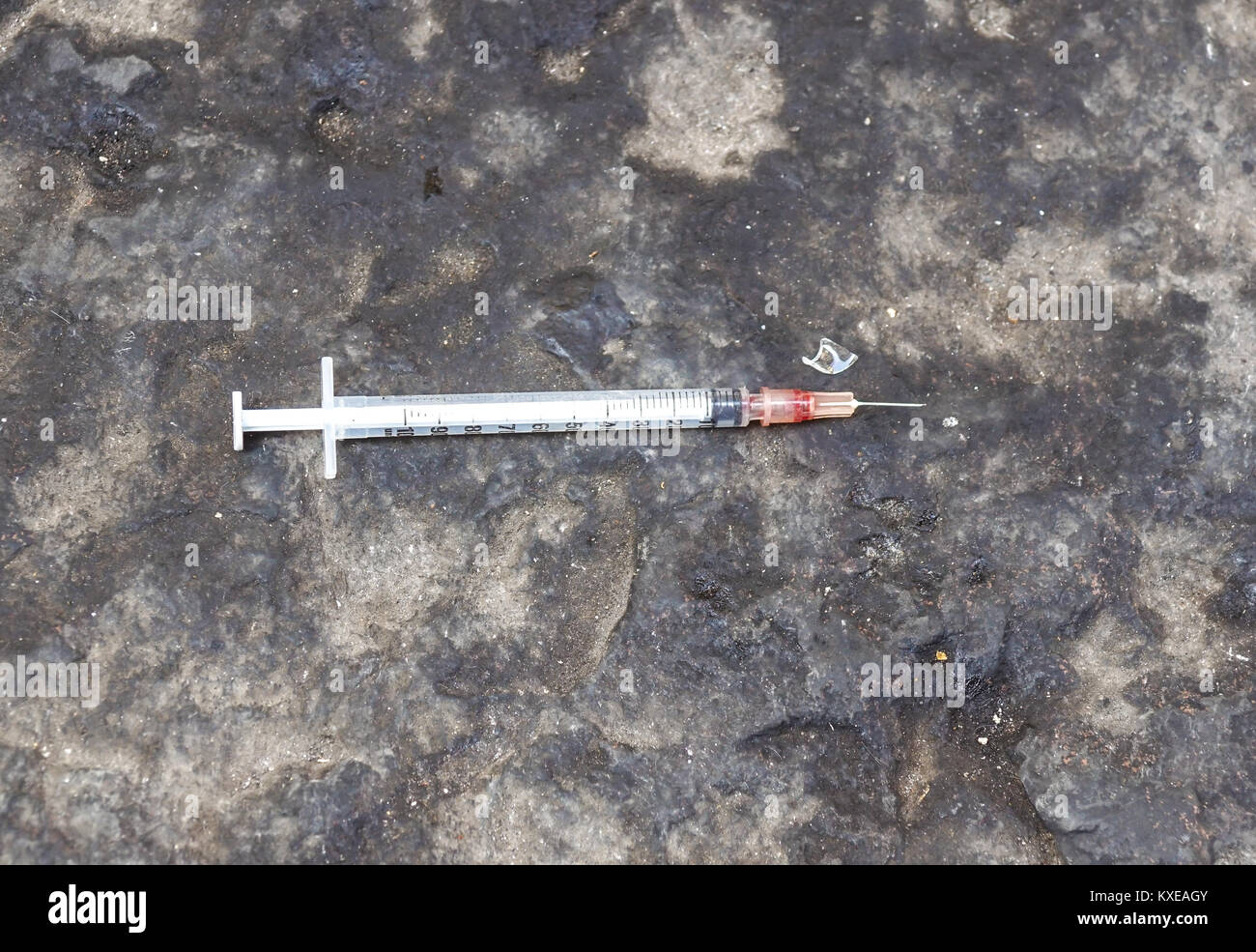 substance abuse, addiction and drug use concept - close up of used syringes on ground Stock Photo