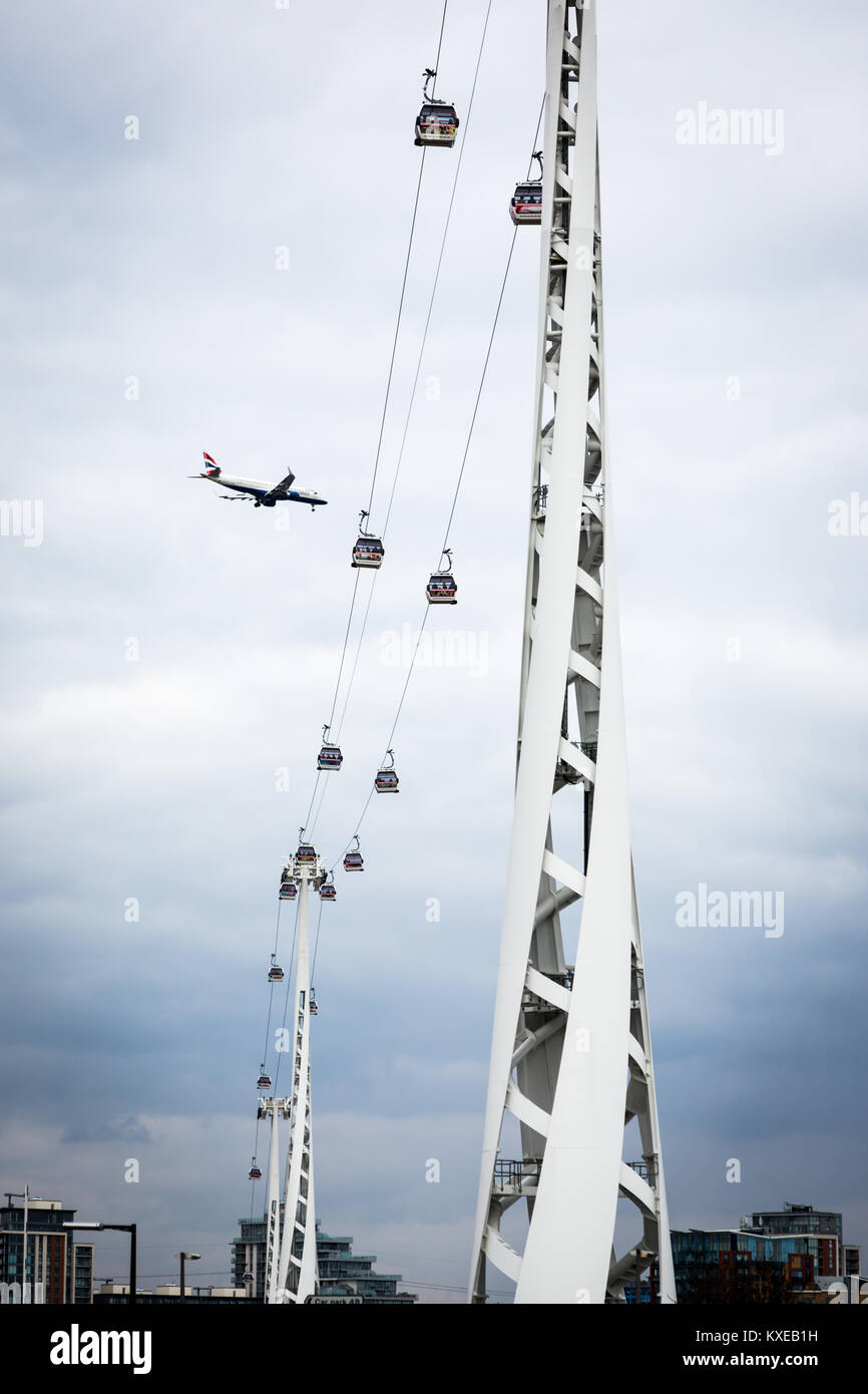 A passenger plane crosses the Emirates Air-Line cable car service as it ...