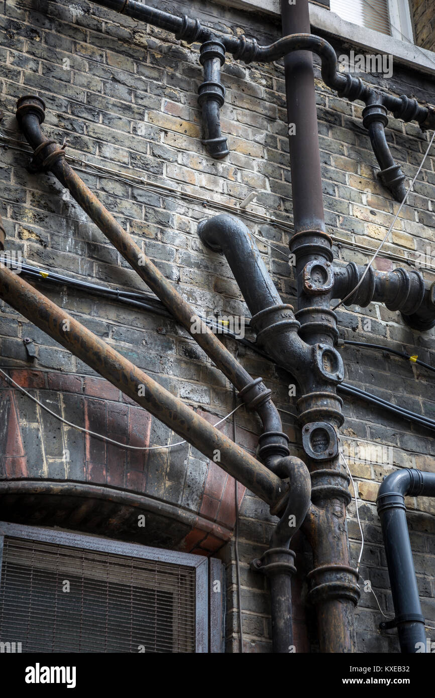 Old iron drain pipes on the side of a building Stock Photo