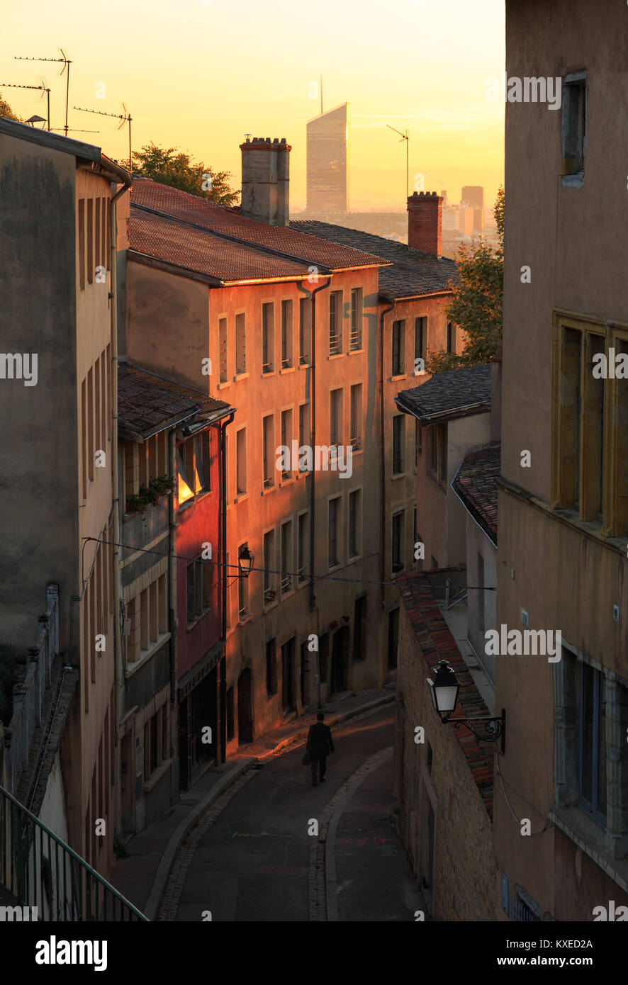 A man walking in a charming alley in Vieux Lyon, the old town of Lyon, during sunrise. Stock Photo