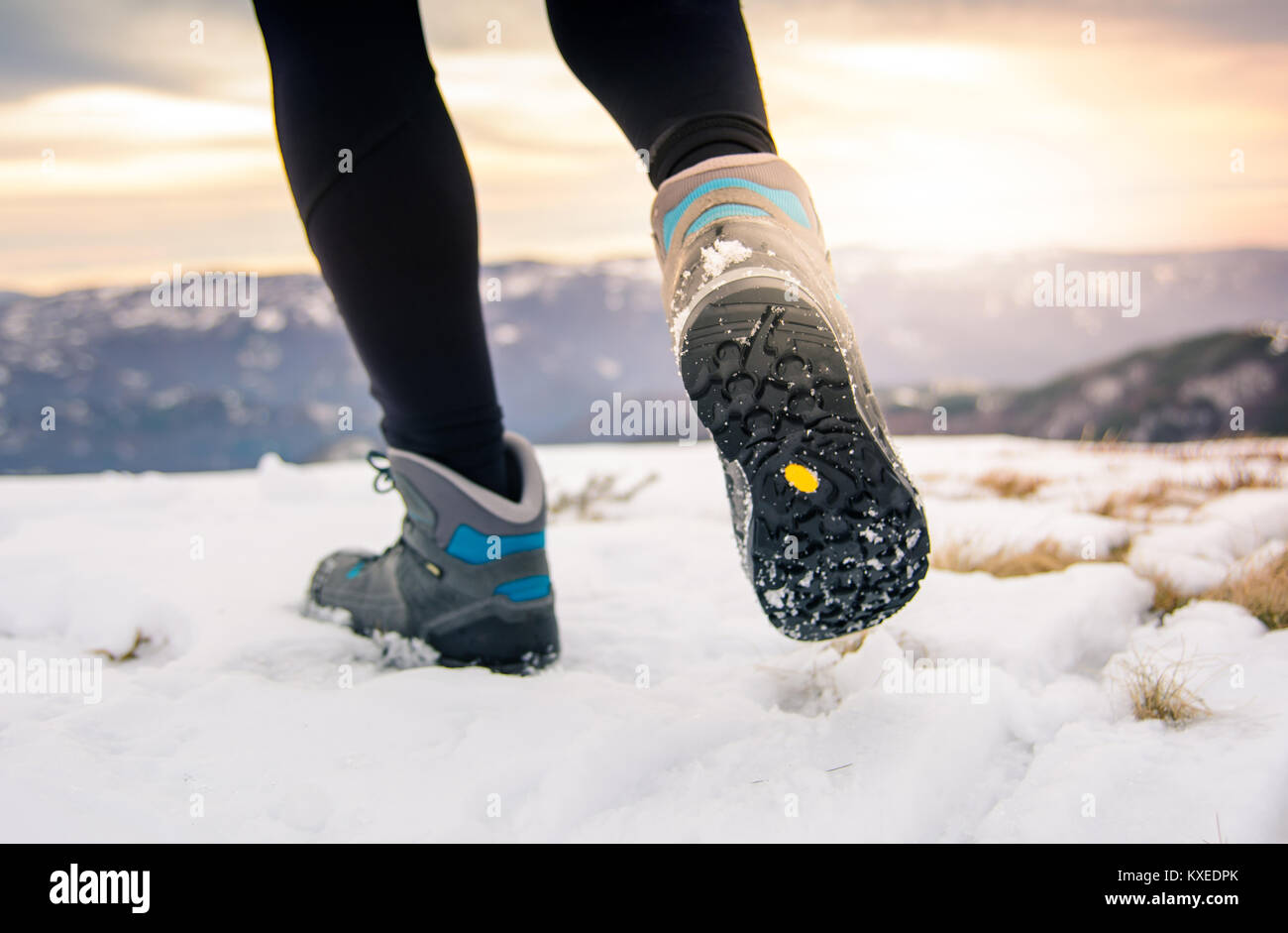 Person hiking on the mountaintop covered with snow low angle view Stock Photo