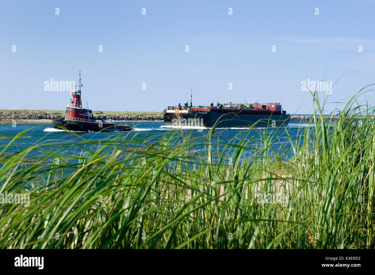 A tug with oil barge going through the Cape Cod Canal in Sandwich, Massachusetts Stock Photo