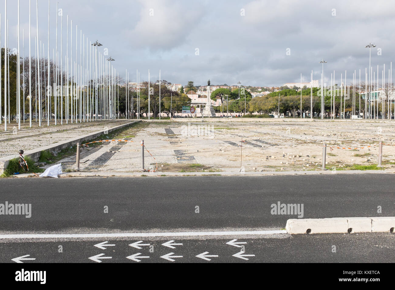 Neglected large square on Av Brasilia in Portugal with rows of flag poles and crumbling surface Stock Photo