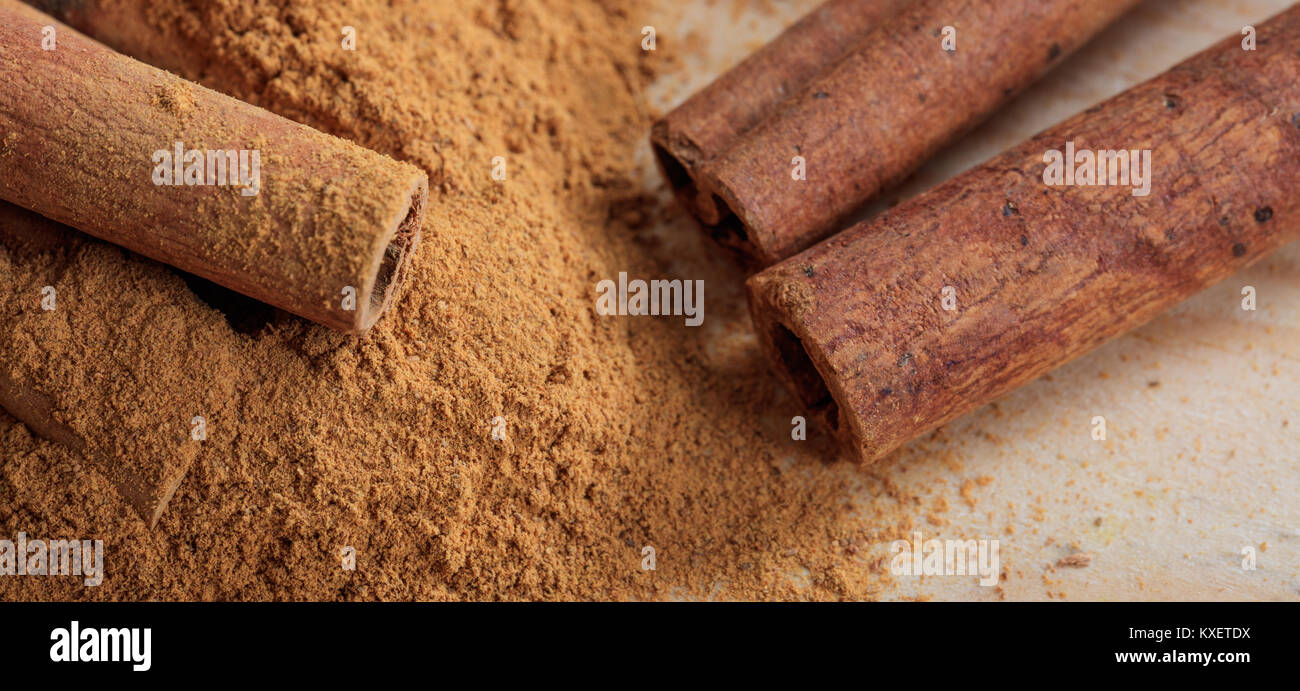 Cinnamon sticks and powder on a wooden surface Stock Photo