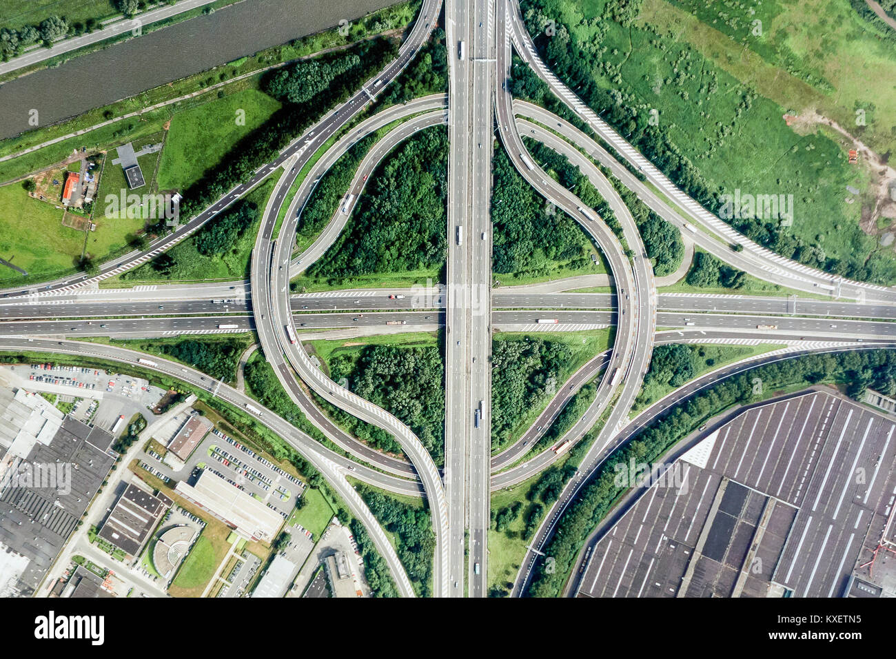 Aerial view over highway roundabout interchange  / motorway interchange with slip roads leading to industrial estate Stock Photo