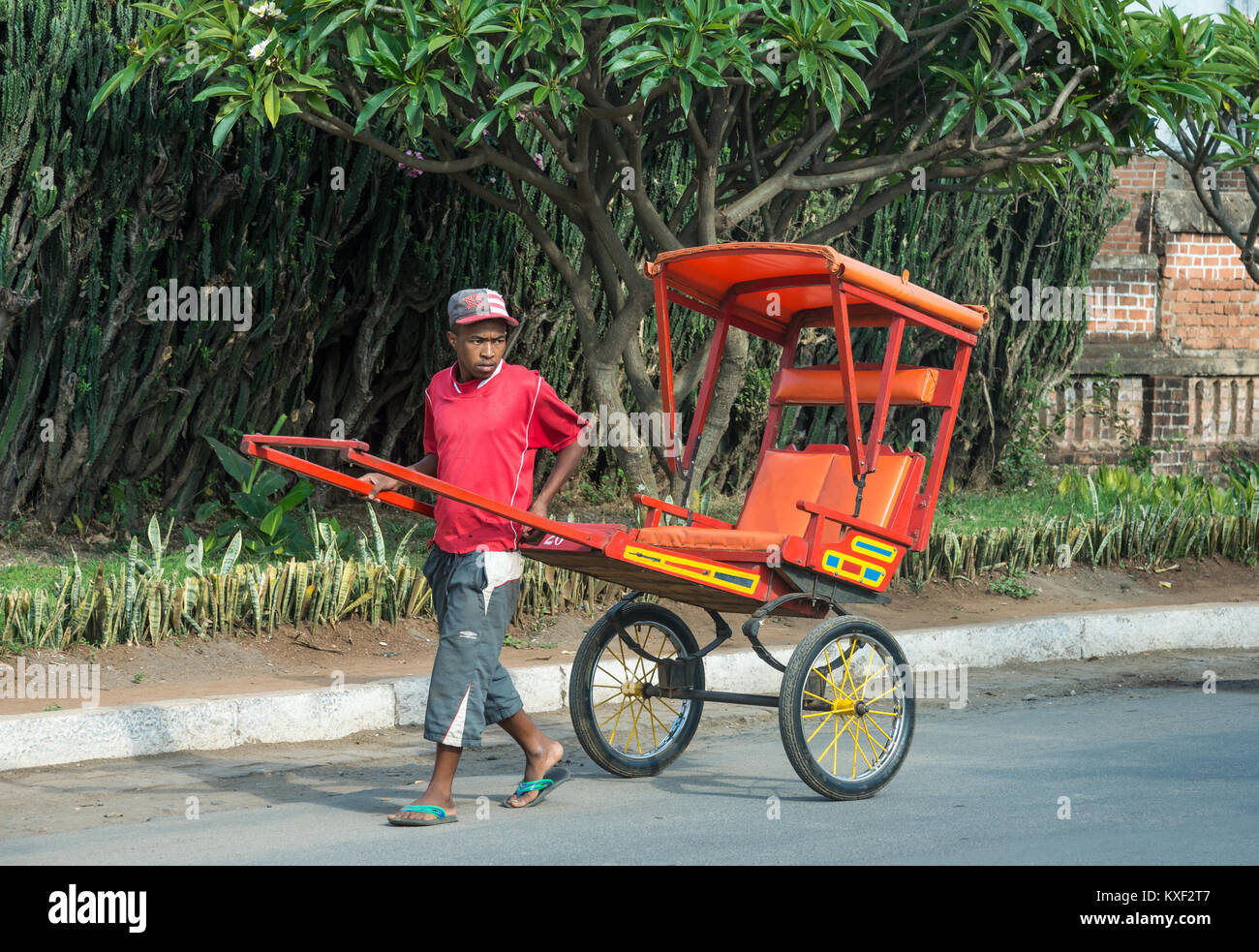 A man pulling a rickshaw on the street of small town Antsirabe, Madagascar, Africa. Stock Photo