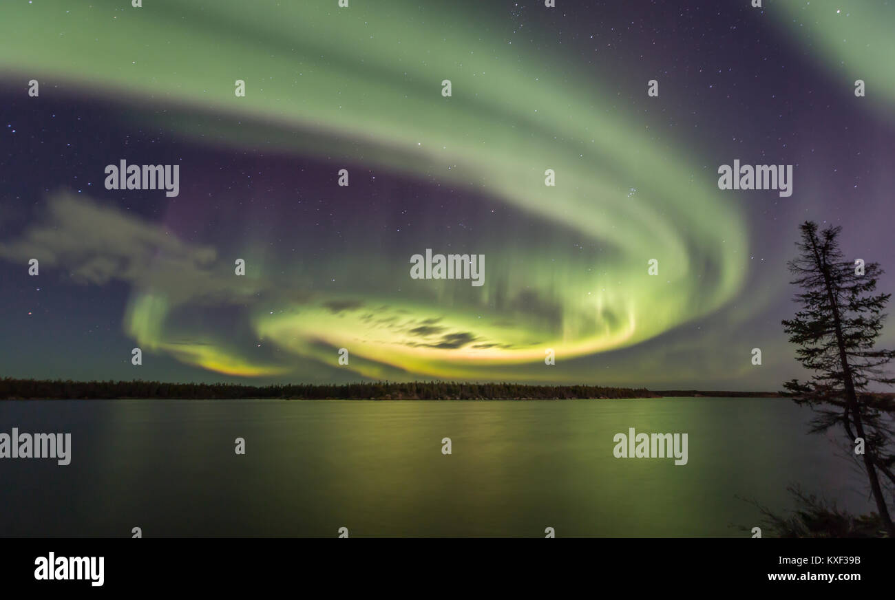 Aurora Borealis swirling in the night sky above Long Lake, Yellowknife, Northwest Territories, Canada.Aurora season is from late August to late March. Stock Photo