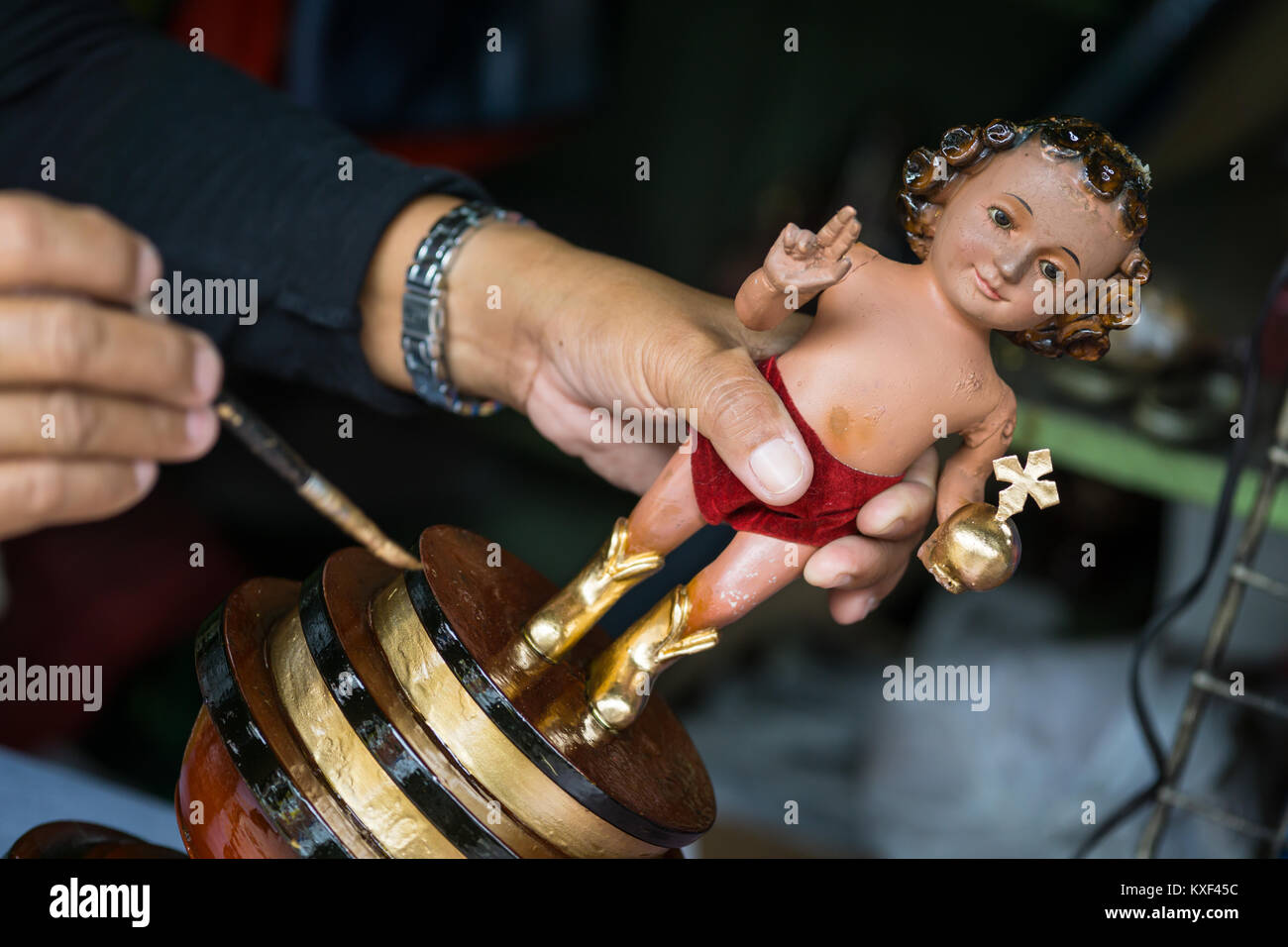 A street vendor repairing a Santo Nino Figurine in the build up to the Sinulog Festival,Cebu City,Philippines Stock Photo