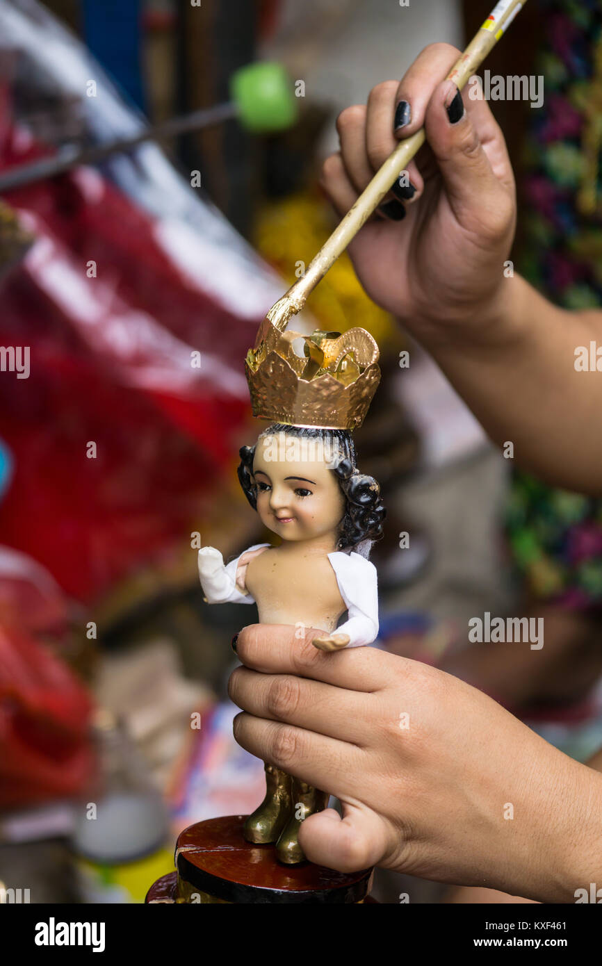 A street vendor repairing a Santo Nino Figurine in the build up to the Sinulog Festival,Cebu City,Philippines Stock Photo