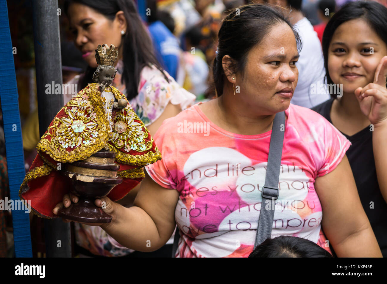 Woman holding a Santo Nino Figurine in the build up to the Sinulog Festival,Cebu City Stock Photo