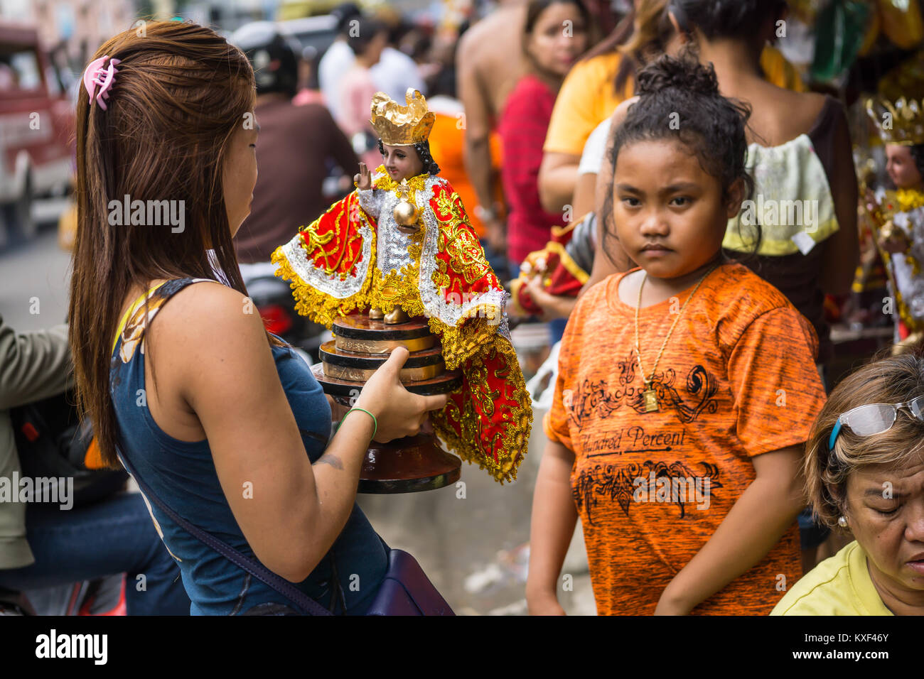 Woman holding a Santo Nino Figurine in the build up to the Sinulog Festival,Cebu City Stock Photo