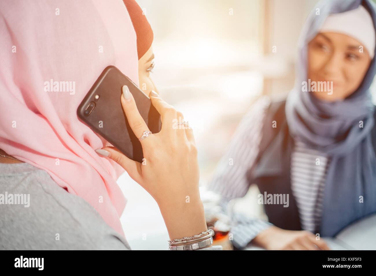 portrait of happy asian woman wearing hijab calling with mobile phone ...