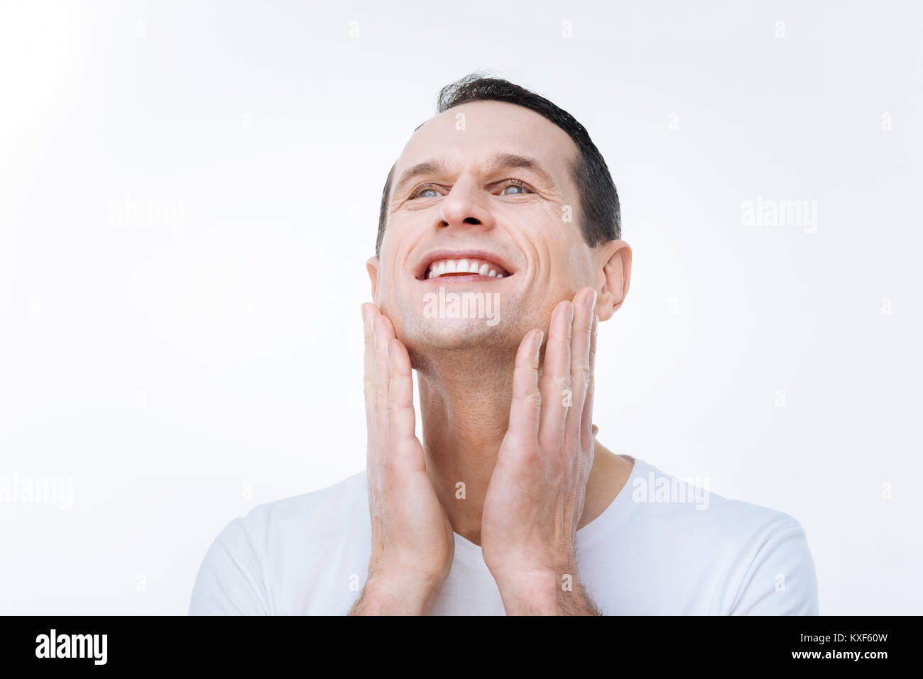 Happy positive man touching his cheeks Stock Photo - Alamy