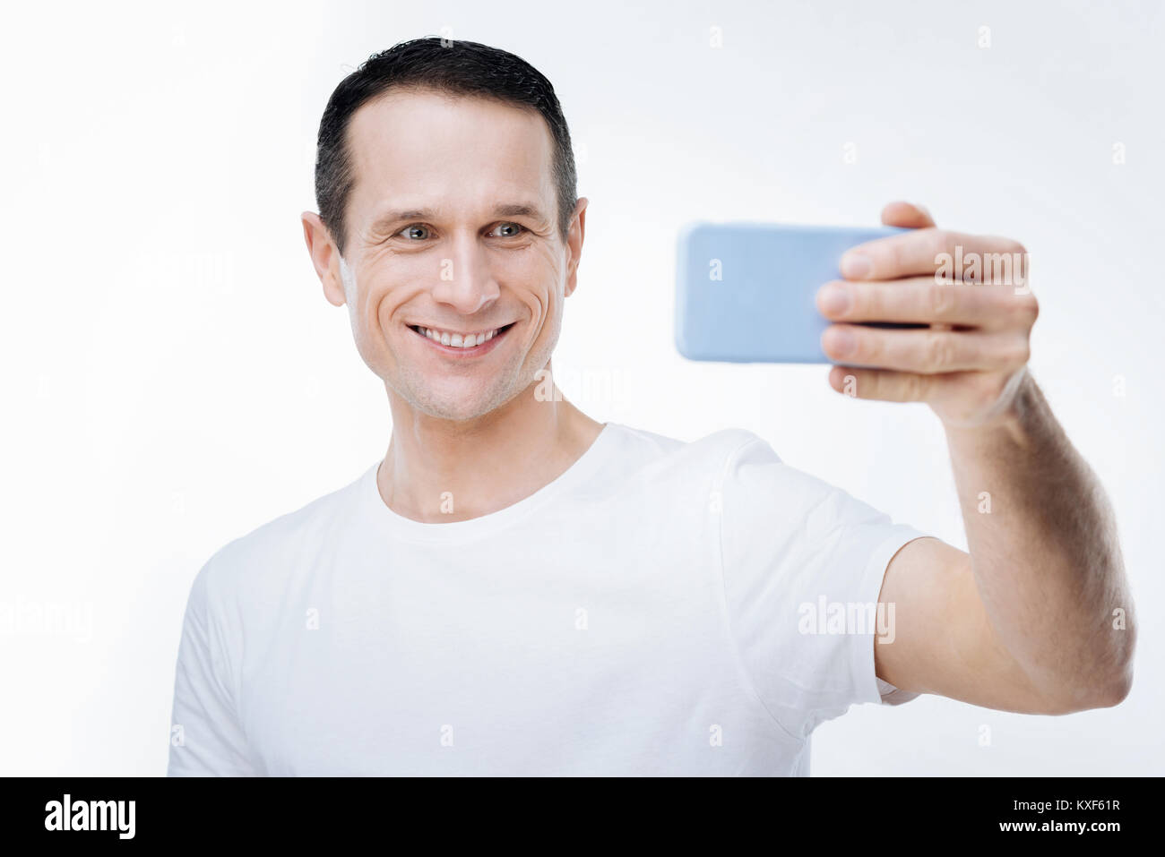 Positive joyful man looking into the smartphone camera Stock Photo