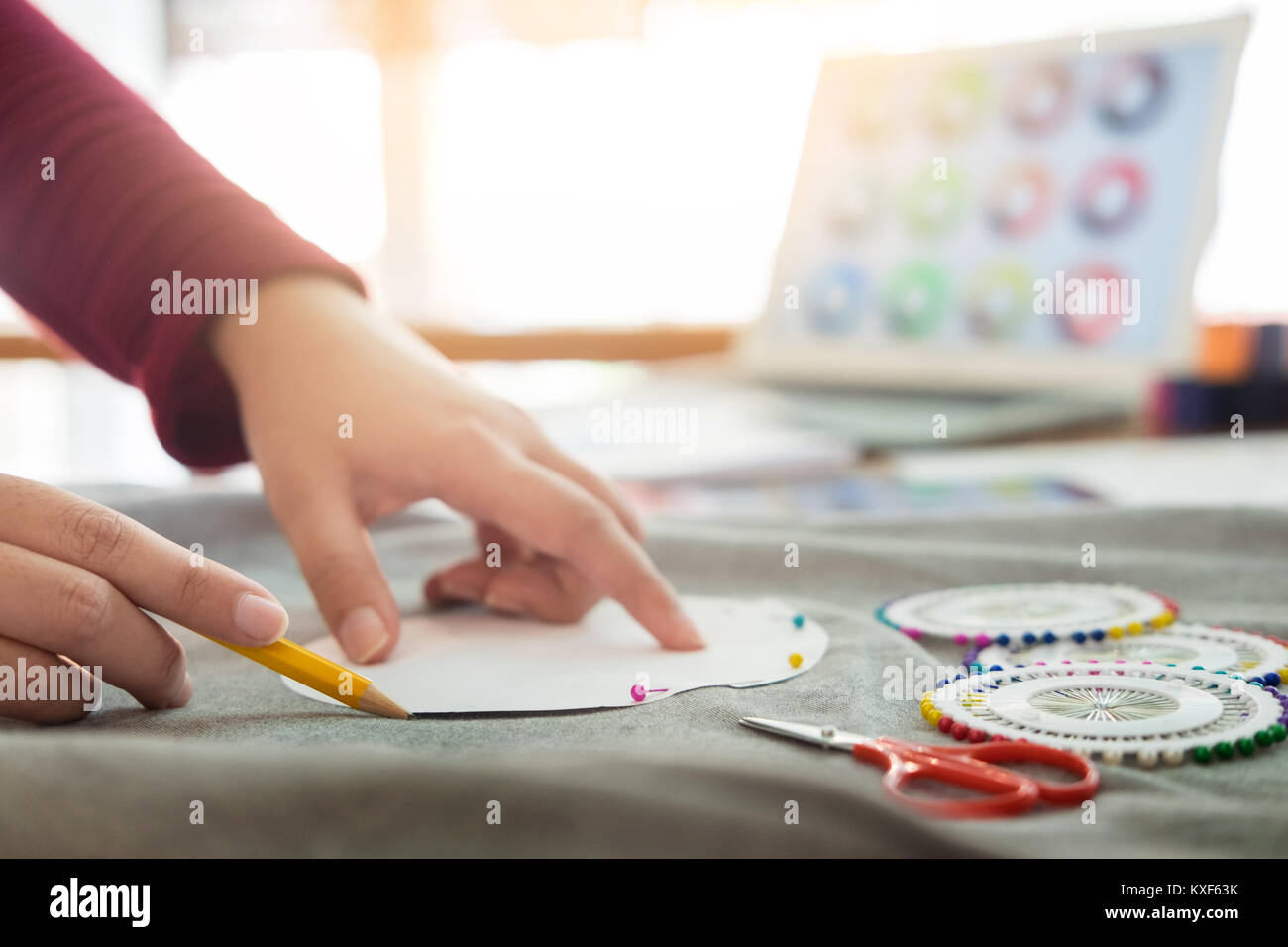 Female fashion designer working with sketches at studio and choosing ...