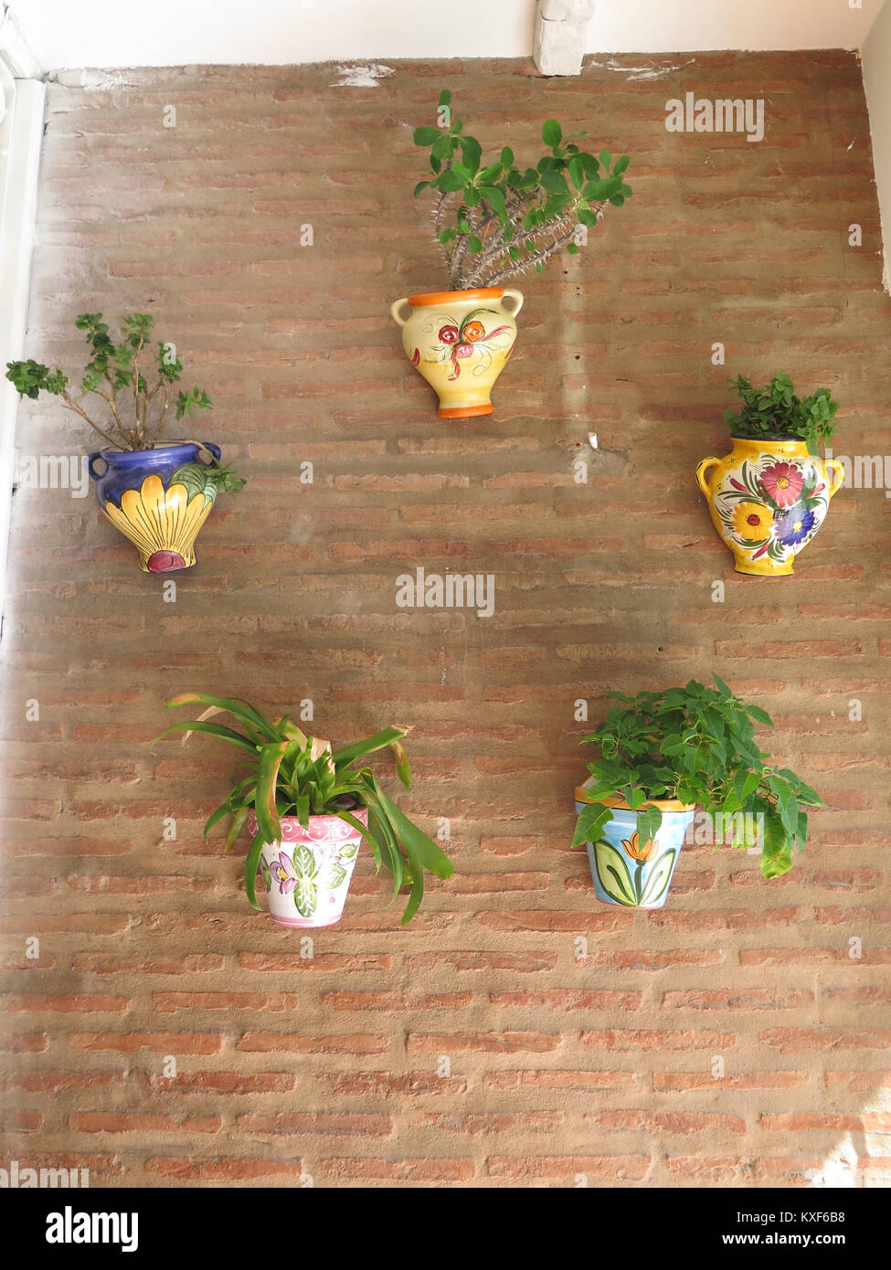 Andalusian Flower pots hanging on Brick Wall Stock Photo