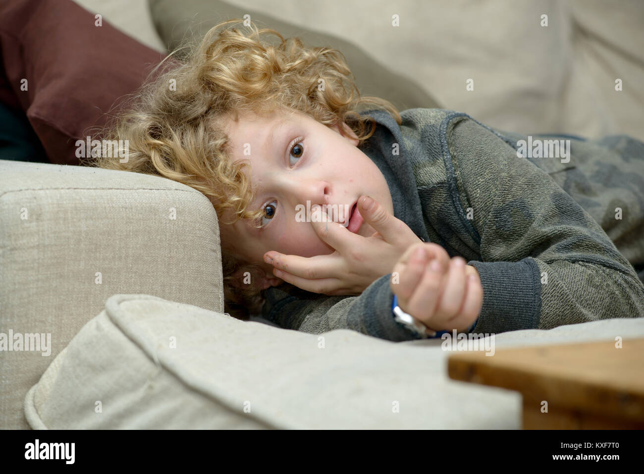 a blond young boy finger in the nose Stock Photo