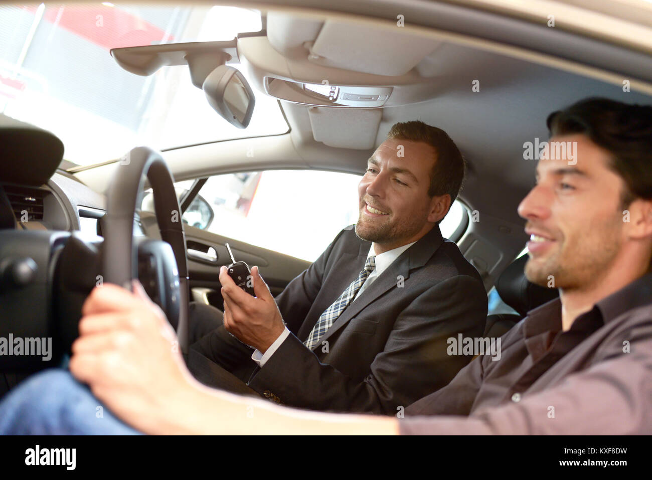 car salesmen and customers talk about the technology of a car in the