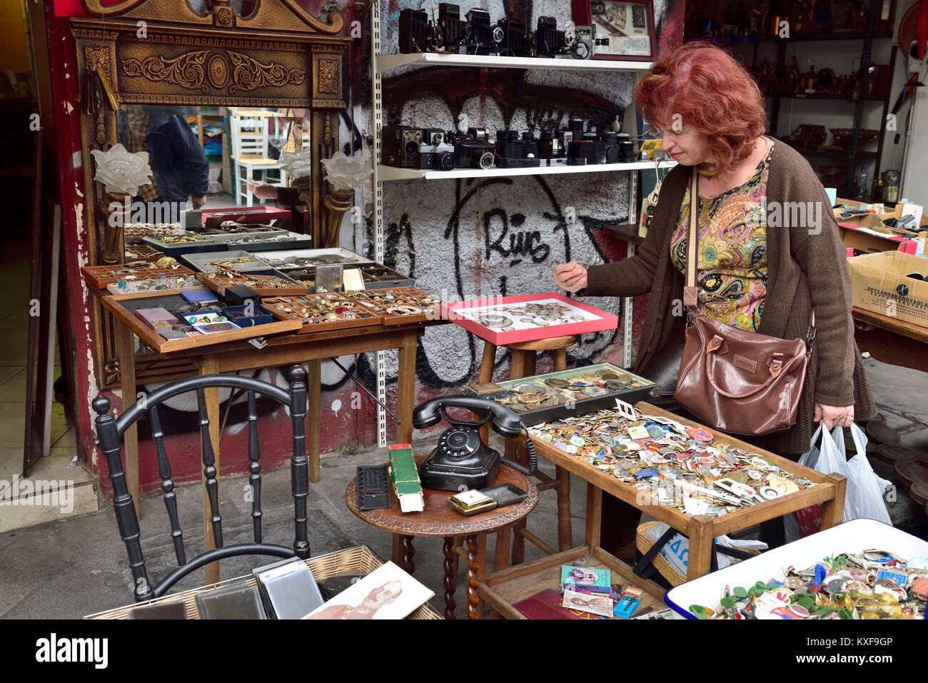 Woman at flea market looking at bric-a-brac in antiques stall, Athens, Greece Stock Photo