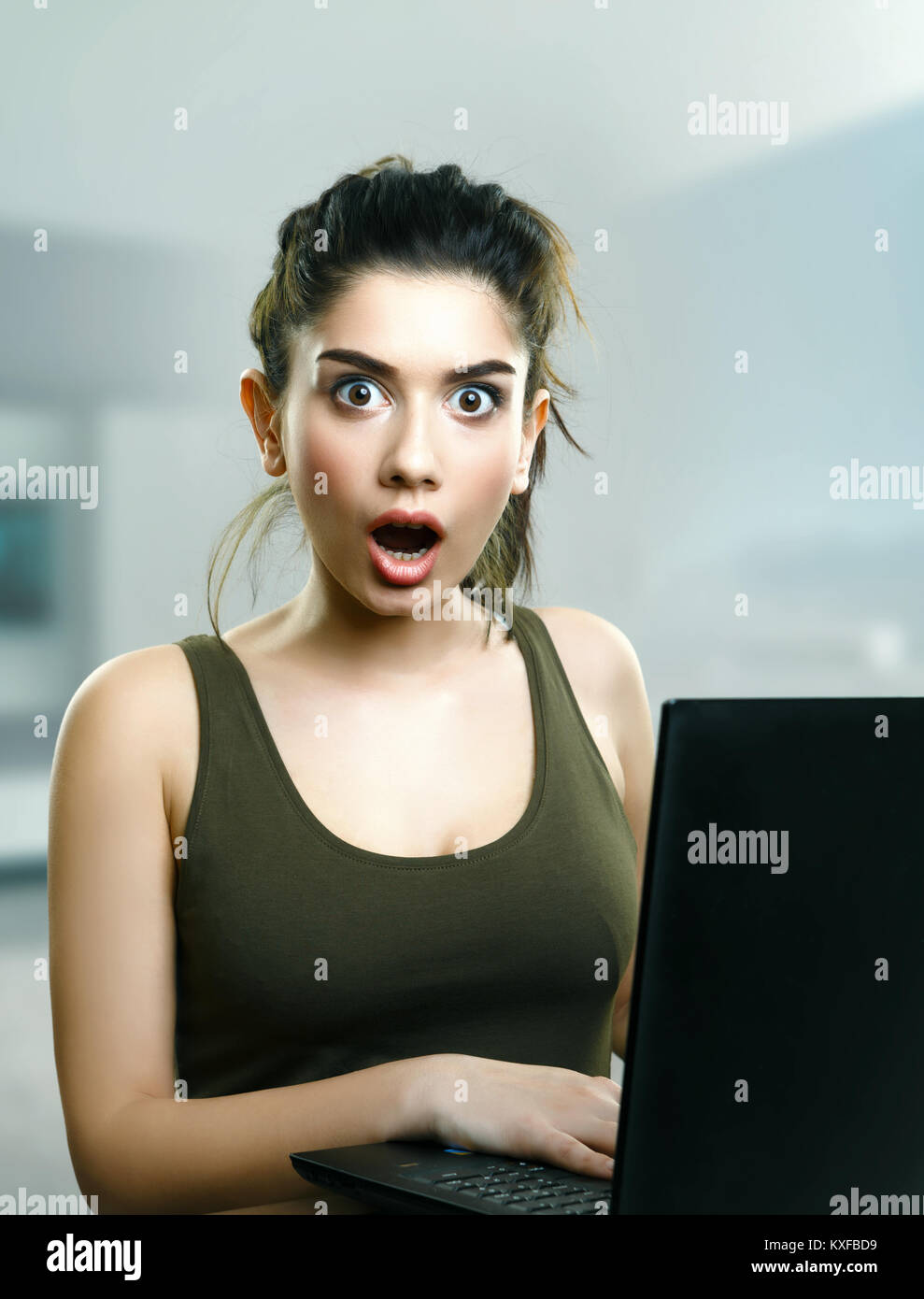 Surprised girl shocked by online laptop media news Stock Photo