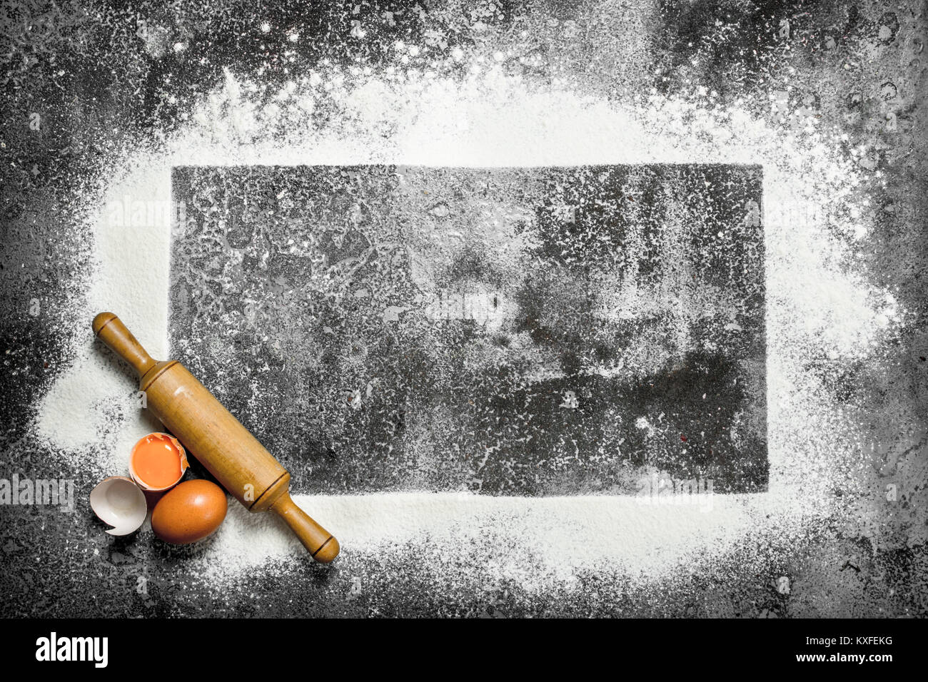 Baking background. A frame of flour with a rolling pin and fresh eggs ...