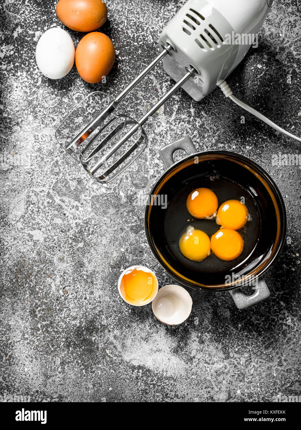 Baking background. Blend eggs with a mixer to make a dough. On a rustic