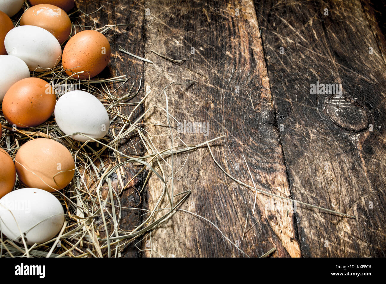 Chicken eggs on the straw. On a wooden background Stock Photo - Alamy