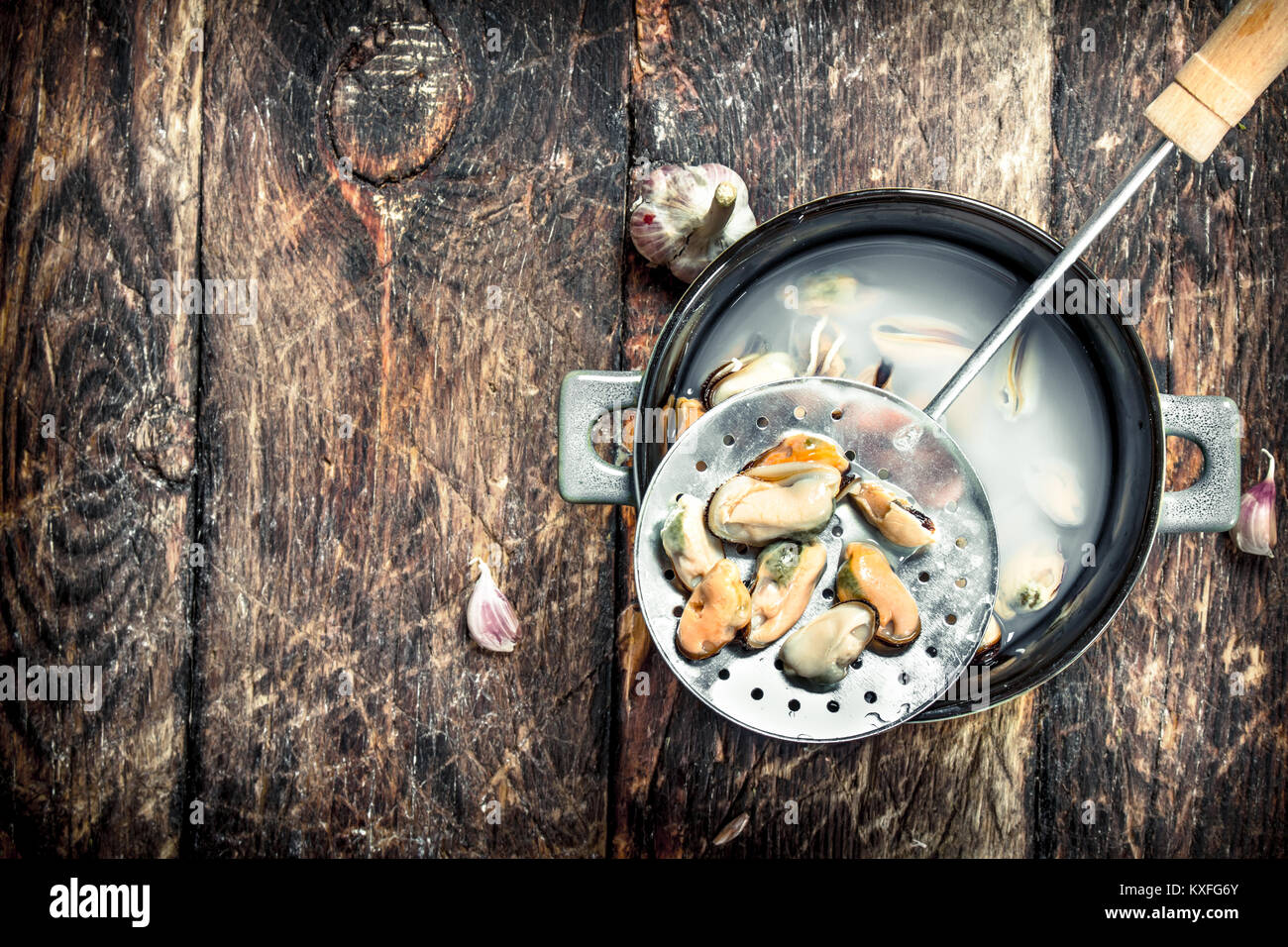 Boiled mussels in a bowl. On a wooden background. Stock Photo